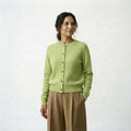 Spanish woman wearing a light green cardigan and beige pants