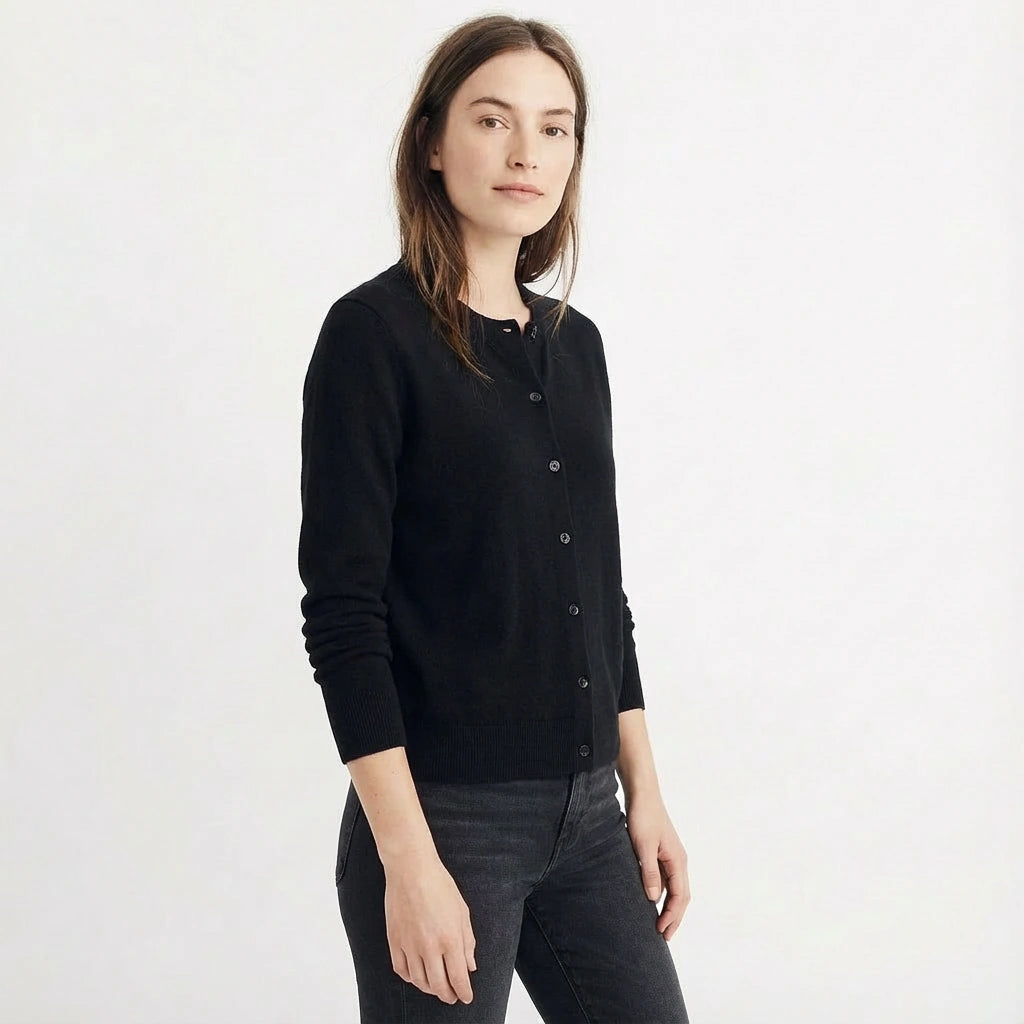 Brunette woman wearing a black wool cardigan on a white background