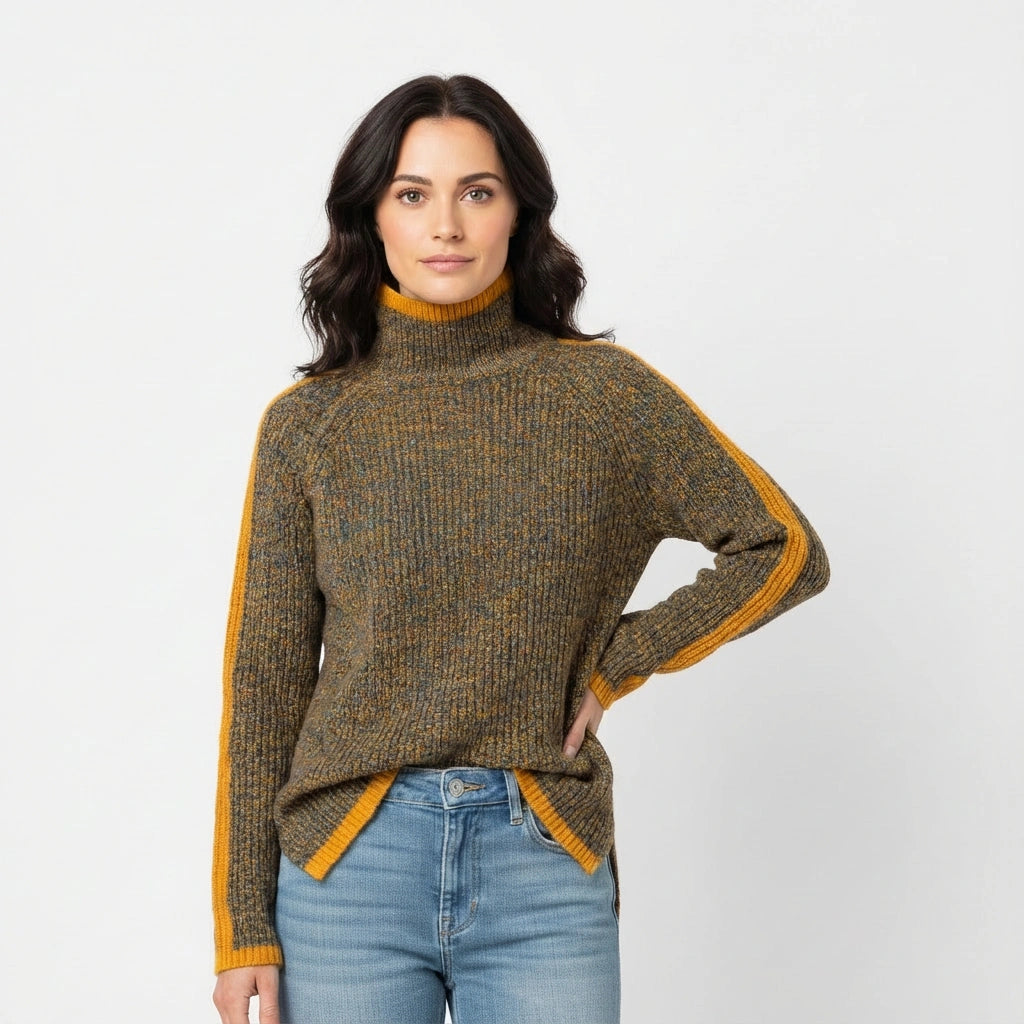 Woman wearing a turtleneck sweater with yellow accents and blue jeans on a white background