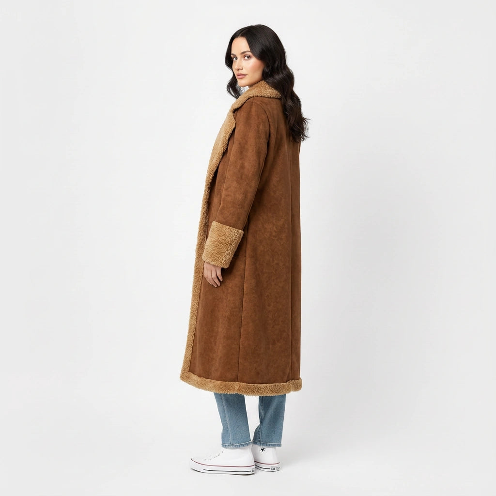 Woman turned away slightly wearing a brown coat with faux shearling trim on a white background