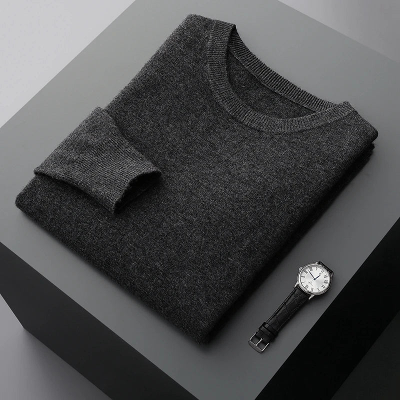 Folded gray brexton men's merino wool sweater and watch on a gray surface