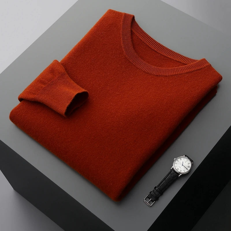 Folded maroon brexton men's merino sweater on a gray surface with a watch beside it