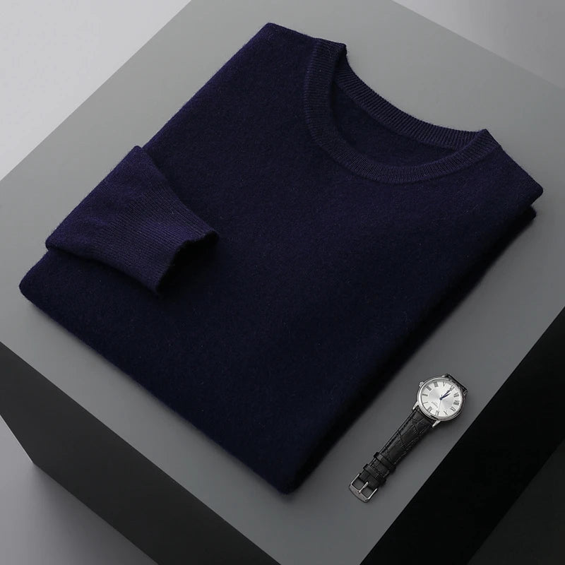 Folded brexton navy blue men's merino sweater with a watch on a gray surface