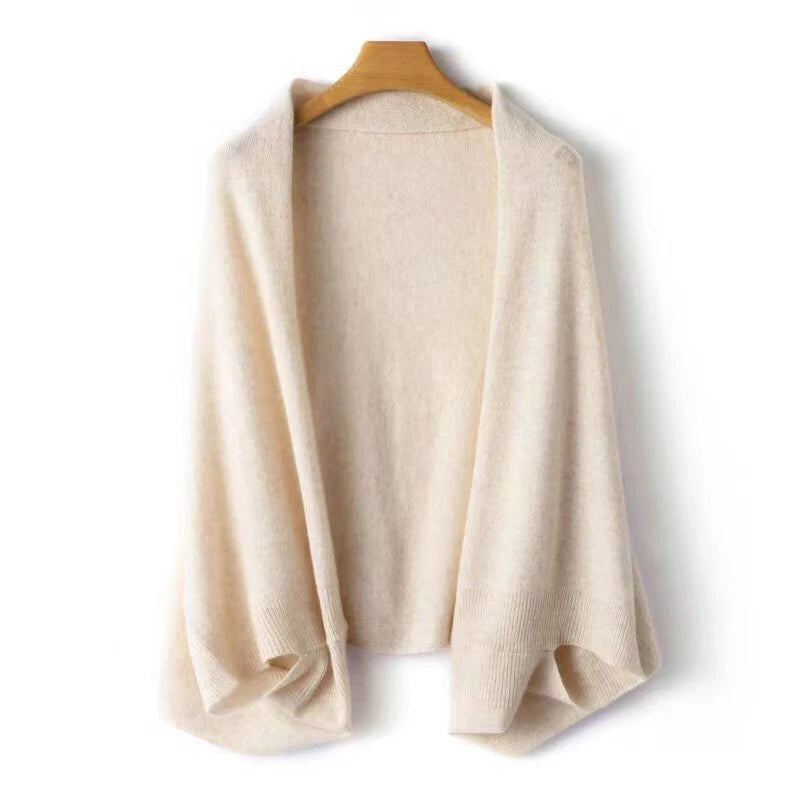 Beige wool wrap shawl on a wooden hanger against a white background