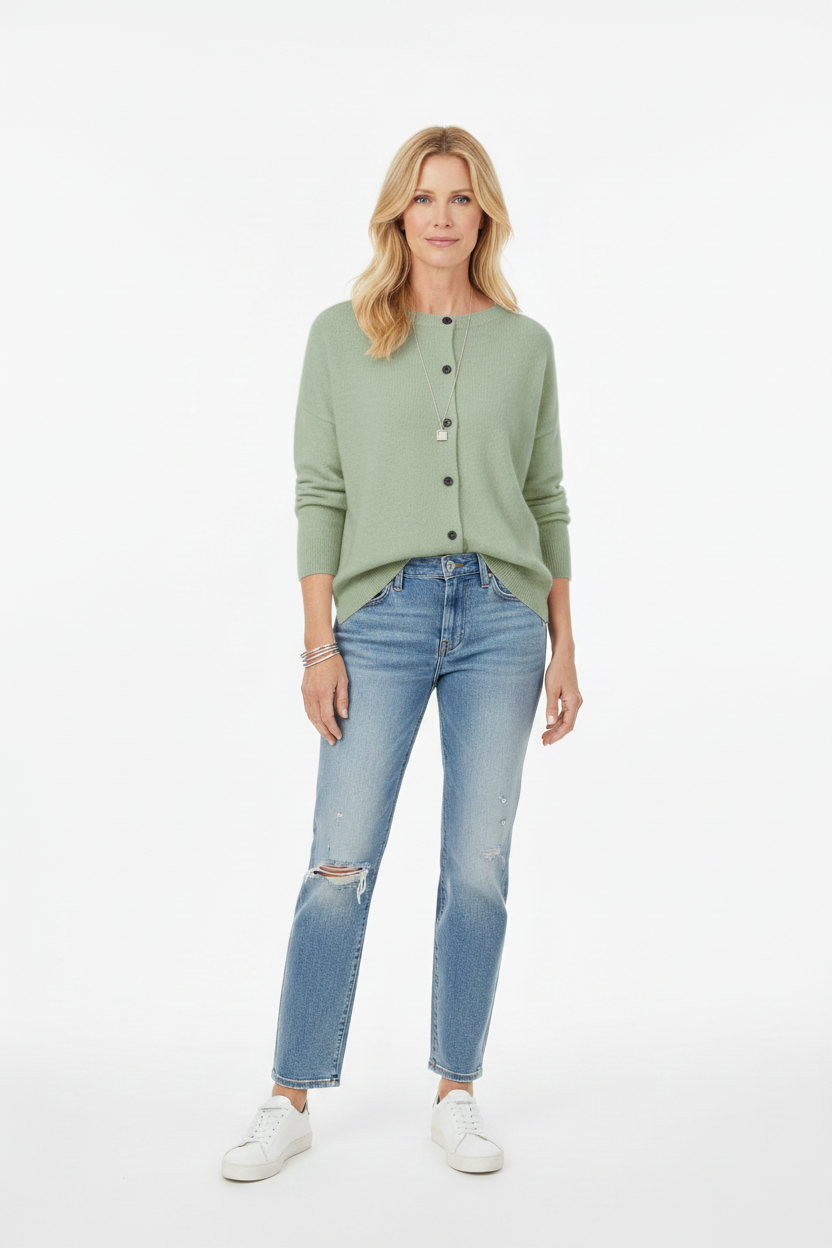 Standing woman wearing a turqoise green wool cardigan and blue jeans
